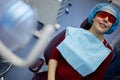 Smiiling woman in protective red glasses sits on Royalty Free Stock Photo