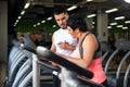 Smiing middle aged woman and fitness coach in gym