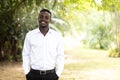 Smile african man wearing smart white shirt standing in the green nature background Royalty Free Stock Photo