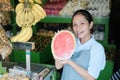 Smile Asian woman in apron holding a watermelon