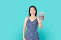 Smile Asian woman holding calculator isolated on blue background. Royalty Free Stock Photo