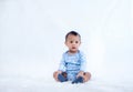 Smile baby boy is shooting in the studio. fashion image of baby and family. Lovely baby sit down on a soft white carpet.