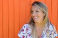 Smile beauty girl in summer woman with long blonde hairs in orange wooden background