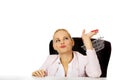 Smile business woman sitting behind the desk and holding small shopping basket Royalty Free Stock Photo