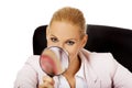 Smile business woman sitting behind the desk and looking into a magnifying glass Royalty Free Stock Photo