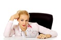 Smile business woman sitting behind the desk with small shopping basket Royalty Free Stock Photo