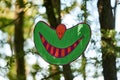 Smile of Cheshire cat hanging art object in public park, funny cute smile hanging in woods