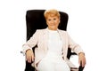 Smile elderly business woman sitting on armchair Royalty Free Stock Photo