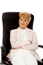 Smile elderly business woman sitting on armchair Royalty Free Stock Photo