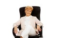 Smile elderly business woman sitting on armchair Royalty Free Stock Photo