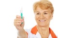 Smile elderly female doctor or nurse holds syringe Royalty Free Stock Photo