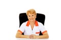 Smile elderly female doctor or nurse sitting behind the desk Royalty Free Stock Photo