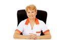 Smile elderly female doctor or nurse sitting behind the desk Royalty Free Stock Photo