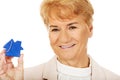 Smile elderly woman holding blue key pendant Royalty Free Stock Photo