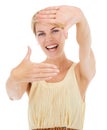 Smile. An excited young woman framing you with her hands while isolated on a white background. Royalty Free Stock Photo