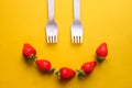 Smile face made from strawberries and eco-friendly disposable wooden forks.
