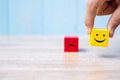 Smile face on yellow wood cube and sad face icon on red wood cube. Service rating, ranking, customer review, satisfaction and Royalty Free Stock Photo