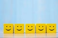 Smile face on yellow wood cube. Service rating, ranking, customer review, satisfaction and emotion concept Royalty Free Stock Photo