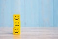 Smile face on yellow wood cube. Service rating, ranking, customer review, satisfaction and emotion concept Royalty Free Stock Photo