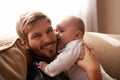 Smile, father and face with baby on sofa in home living room, playing or bonding together. Kiss, care and dad with Royalty Free Stock Photo