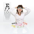 Smile female face chooses spectacles on eyesight test chart Royalty Free Stock Photo