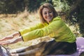 Smile fitness girl exercising outdoors in park, pose with stretch legs, sporty woman stretching exercises training outside. Sports