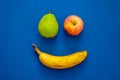 Smile from fruits Ã¢â¬â banana, apple and pear. Blue mat in background