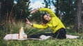 Smile girl exercising outdoors in green park, activity with stretch arms and legs. Young fitness woman laughing doing stretching Royalty Free Stock Photo