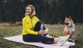 Smile girl with pet together relax after exercising outdoors on yoga mat, shiba dog on nature with fitness woman drink water