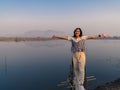 Smile happy Asian woman tourist standing freedom arms open at beautiful calm mountain landscape with front lake reflection Royalty Free Stock Photo