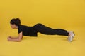 Smile happy Beautiful portrait young Asian woman stretching exercise and plank workout on yellow background, fitness sport girl Royalty Free Stock Photo