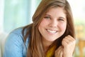 That smile lights up a room. A pretty teenager smiling at you happily while relaxing at home. Royalty Free Stock Photo