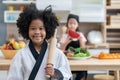 Smile little girl in chef uniform holding rolling pin for preparing to make cake bakery in kitchen Royalty Free Stock Photo