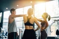 Smile man and women making hands together in fitness gym. Group of young people doing high five gesture in gym after Royalty Free Stock Photo