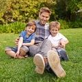 Smile, nature and portrait of children with father relaxing on grass in outdoor park or garden. Happy, family and Royalty Free Stock Photo