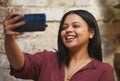 Smile, phone and selfie with woman by wall for social media, contact and post online. Internet, technology or 5g mobile