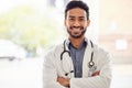 Smile, portrait and asian man doctor with arms crossed in hospital for consulting, exam and help on blurred background