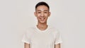 Smile. Portrait of young asian man with clean shaven face smiling at camera isolated over white background. Beauty