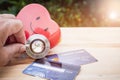 Smile Red heart stethoscope on Mock up Credit Card with cardholder in hospital wood desk. Concept of Health insurance cost of care