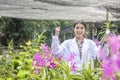 Smile Scientists hold tablets and magnifiers, happy with success. Researcher botanical research orchid wearing Scientist shirt and