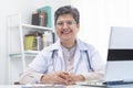 Smile senior asian physician, general woman doctor wearing glasses and white uniform, mature female with stethoscope, working on Royalty Free Stock Photo