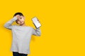 Smile and shocked little boy kid in green grey shirt blank screen of mobile phone on yellow background copy space