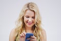 Smile, social media and woman with a smartphone, typing and communication against a grey studio background. Female