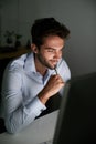 Smile, thinking and businessman with pen by computer for email, internet and working late in office for corporate career Royalty Free Stock Photo