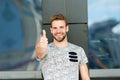 Smile and thumbs up. Handsome guy smiling and gesturing thumbs up. Happy man in casual style extending hand with thumbs Royalty Free Stock Photo