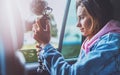 Smile tourist girl in an open window of a auto car taking photography click on digital photo camera, photographer look on camera Royalty Free Stock Photo