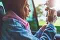 Smile tourist girl in an open window of a auto car taking photography click on digital photo camera, photographer looking on camer