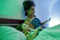Smile the whole day. African american woman baby sitter reading book to cute little girl in the evening. Nanny holding Royalty Free Stock Photo