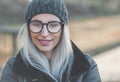 Smile woman face in snowflakes on winter day outdoors. Closeup cute girl wearing warm wool cap and black jacket Royalty Free Stock Photo