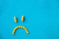Smile of yellow bright yellow pills on a blue background